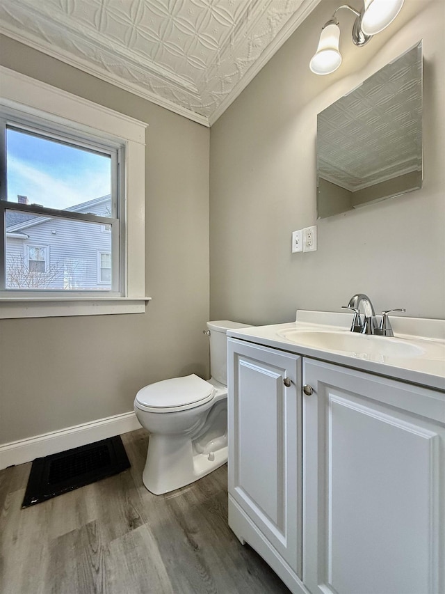 bathroom featuring hardwood / wood-style floors, vanity, toilet, and ornamental molding