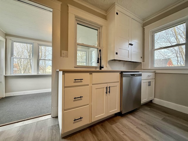 kitchen featuring plenty of natural light, white cabinets, and stainless steel dishwasher