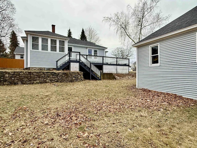 back of property featuring a lawn and a wooden deck