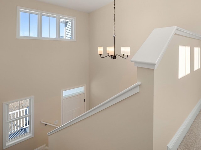 stairway featuring an inviting chandelier