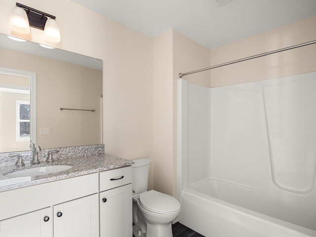 full bathroom featuring washtub / shower combination, vanity, and toilet