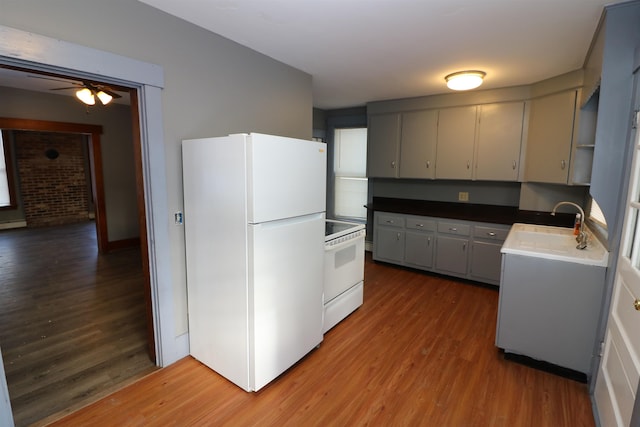 kitchen with white appliances, sink, ceiling fan, gray cabinets, and wood-type flooring