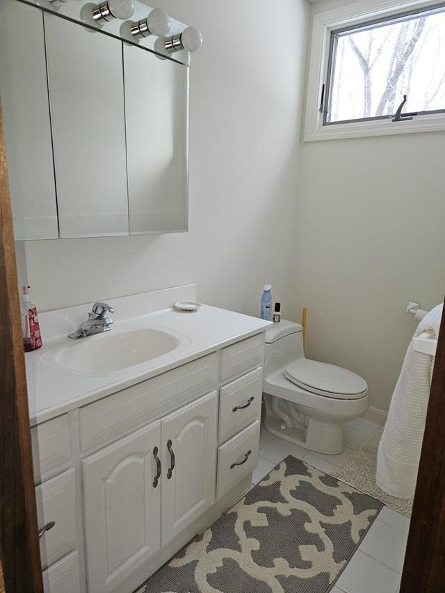 bathroom with tile patterned flooring, vanity, and toilet