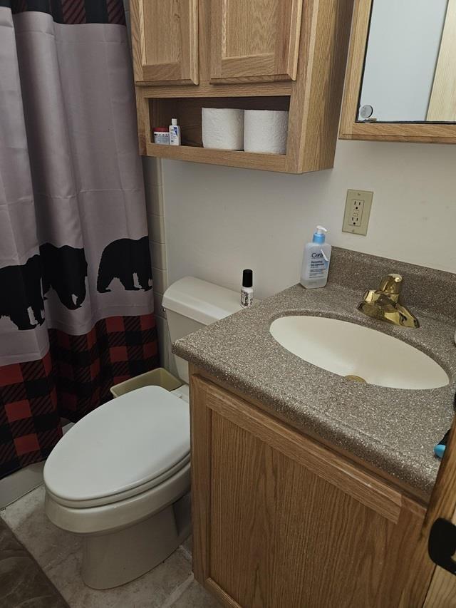 bathroom with tile patterned flooring, vanity, and toilet