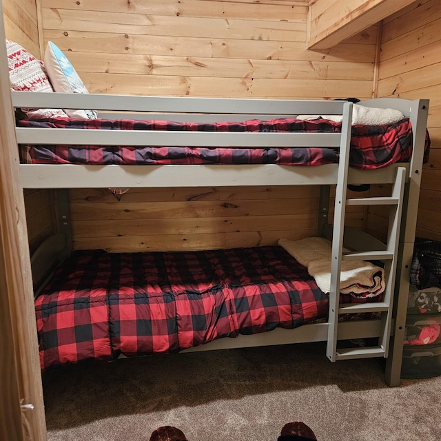 carpeted bedroom featuring wooden walls