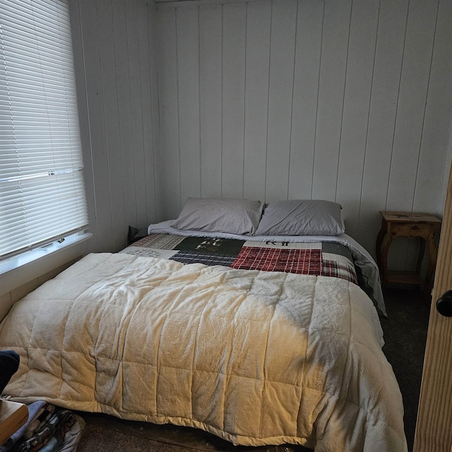 bedroom featuring wood walls