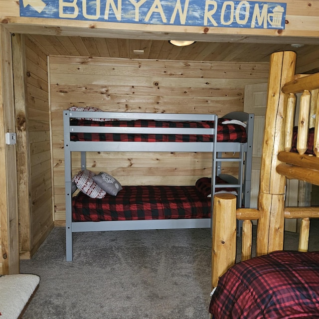 bedroom featuring carpet flooring and wood walls