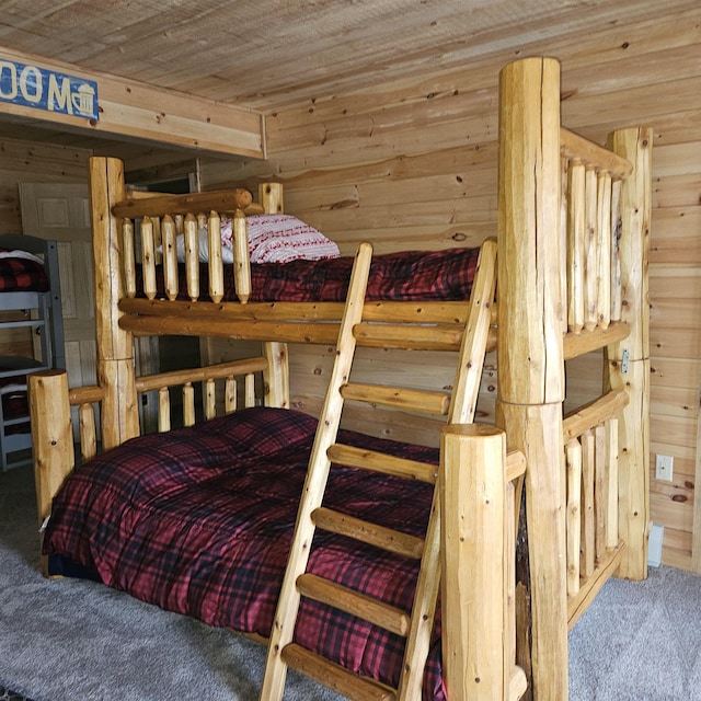 bedroom featuring carpet floors, wooden walls, and wood ceiling