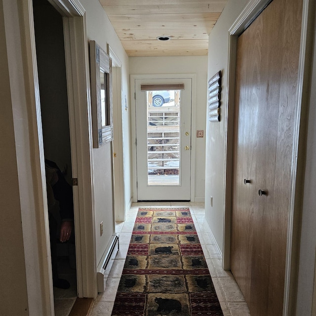 doorway to outside with baseboard heating, light tile patterned floors, and wood ceiling