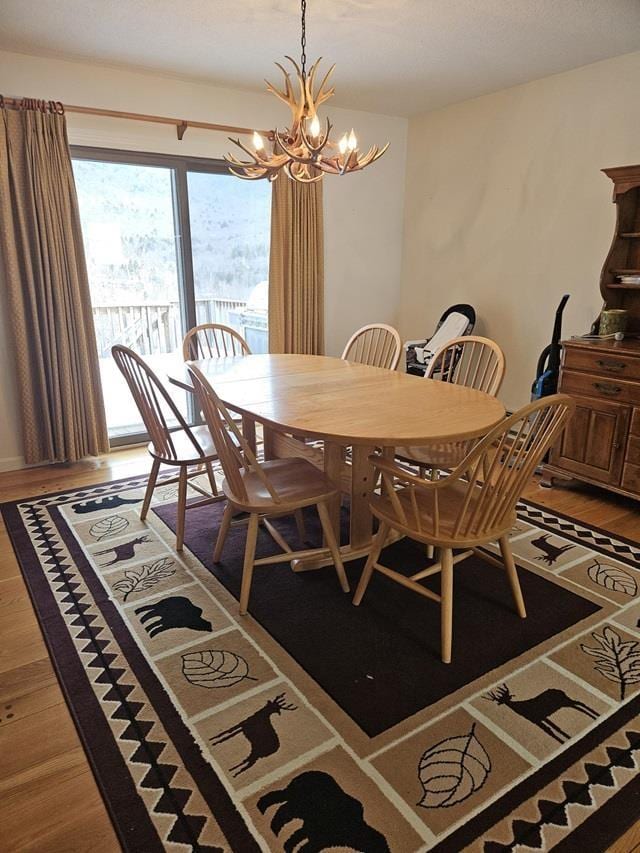 dining space with hardwood / wood-style floors and a notable chandelier