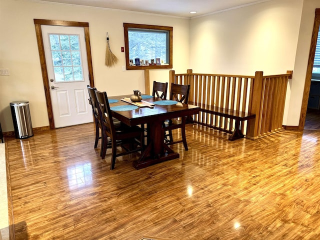 dining space with hardwood / wood-style flooring, plenty of natural light, and ornamental molding