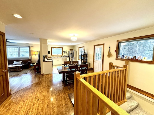 corridor with light hardwood / wood-style floors and sink