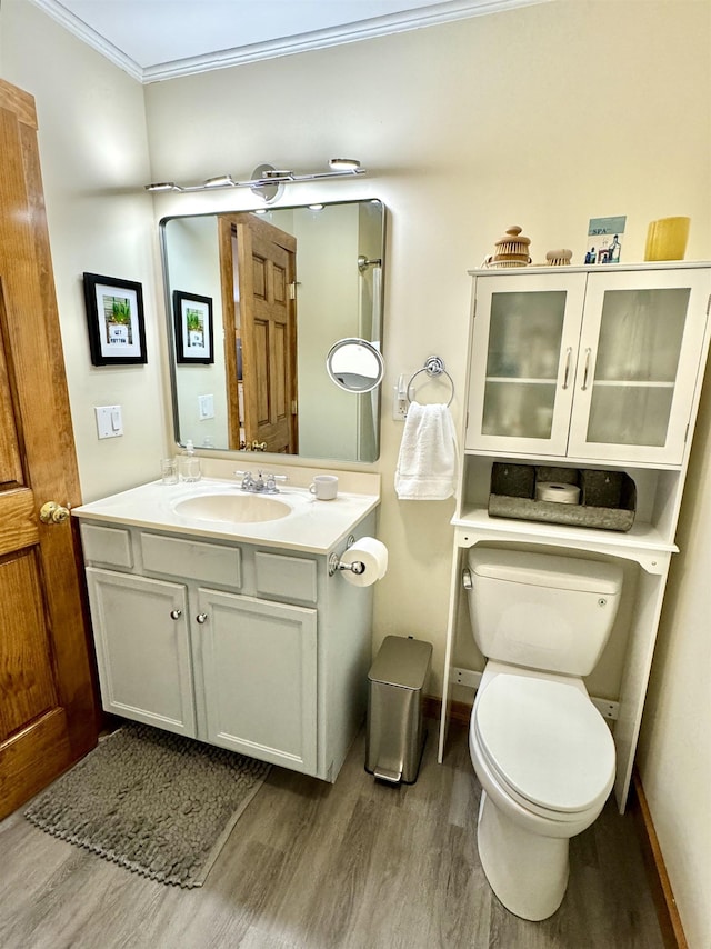 bathroom featuring crown molding, toilet, vanity, and hardwood / wood-style flooring