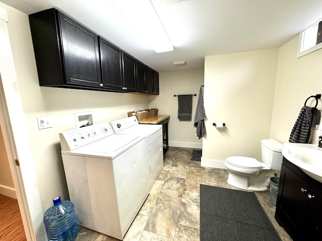 clothes washing area featuring separate washer and dryer, sink, and light hardwood / wood-style floors