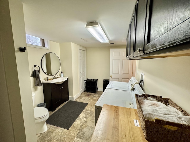 bathroom with vanity, toilet, and washing machine and dryer