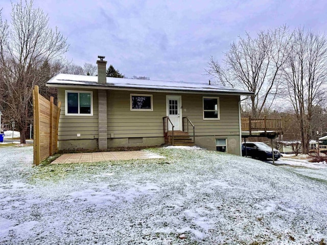 view of snow covered back of property