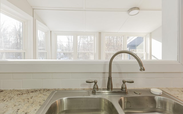 details featuring light stone countertops and sink