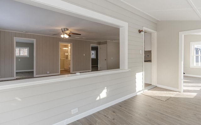 spare room with plenty of natural light, ceiling fan, wood-type flooring, and vaulted ceiling