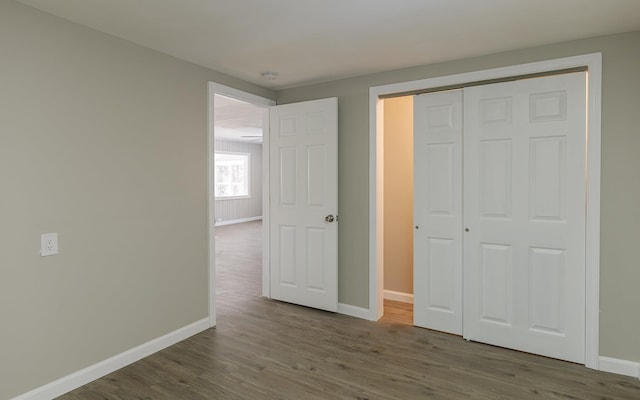 unfurnished bedroom with wood-type flooring and a closet