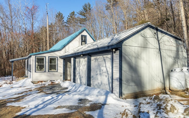 view of snow covered exterior with a garage