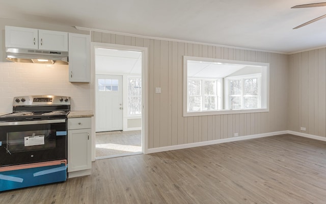 kitchen featuring ceiling fan, light hardwood / wood-style floors, electric stove, decorative backsplash, and white cabinets