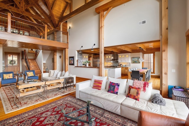 living room featuring beam ceiling, hardwood / wood-style floors, high vaulted ceiling, and wood ceiling