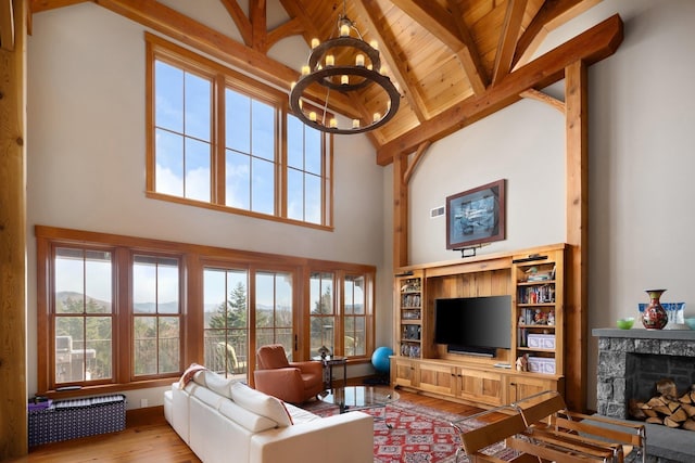 living room with high vaulted ceiling, beam ceiling, a notable chandelier, light hardwood / wood-style floors, and wood ceiling