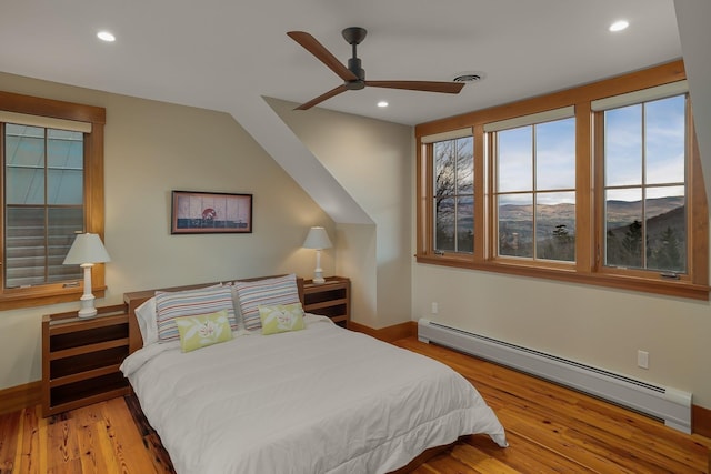 bedroom with ceiling fan, lofted ceiling, baseboard heating, and light hardwood / wood-style flooring