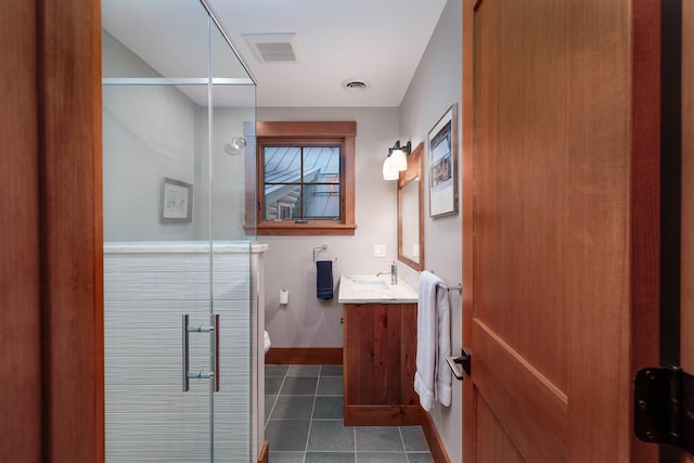 bathroom with toilet, vanity, tile patterned floors, and a shower with door