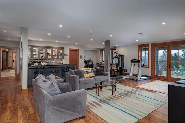 living room featuring bar area, wood-type flooring, and french doors