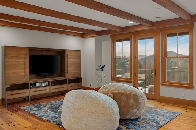 living room featuring beamed ceiling, hardwood / wood-style floors, and a mountain view