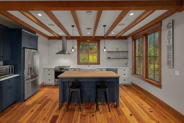 kitchen with tasteful backsplash, white cabinets, stainless steel appliances, and decorative light fixtures