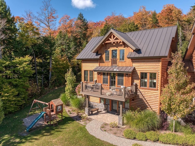 back of property featuring a lawn, a playground, and a patio