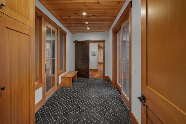 hallway with dark hardwood / wood-style flooring, a barn door, and wooden ceiling