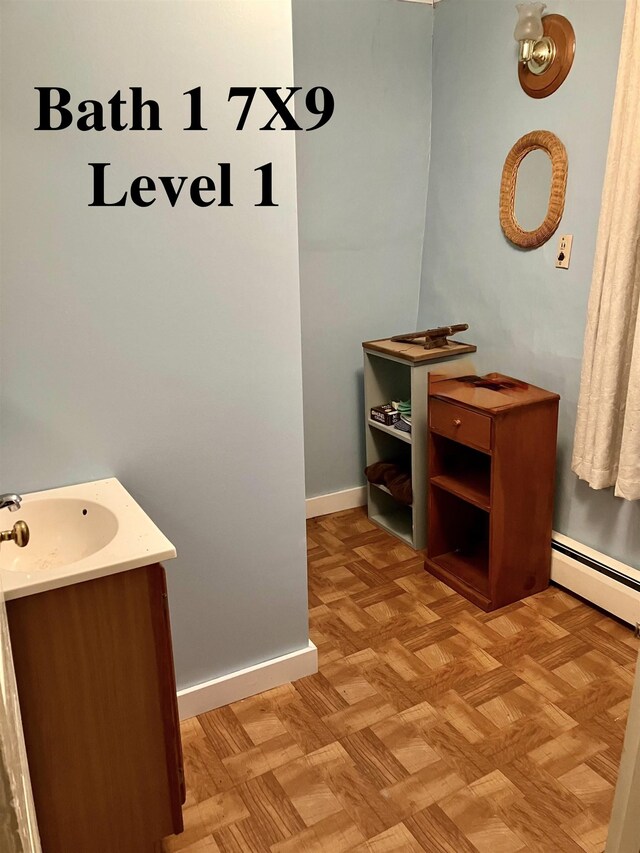 622 S Main St, Danby, VT 05739 - bathroom featuring vanity, parquet floors, and a baseboard heating unit
