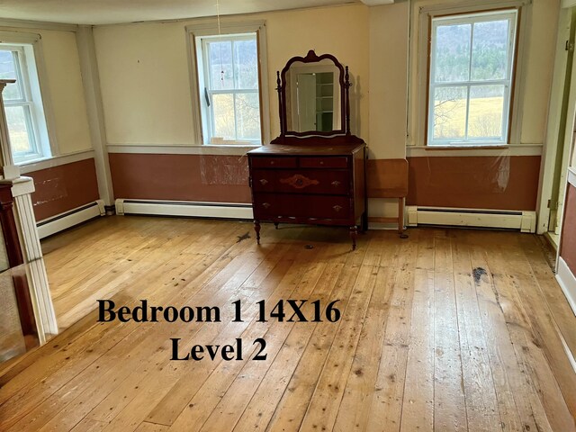 622 S Main St, Danby, VT 05739 - interior space with light hardwood / wood-style flooring, multiple windows, and a baseboard heating unit