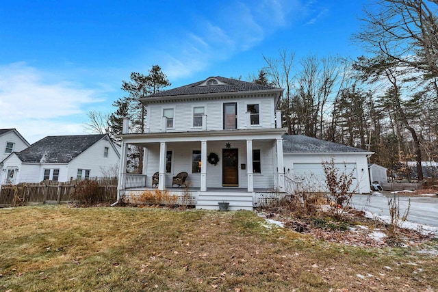 view of front facade with driveway, fence, covered porch, an attached garage, and a front yard