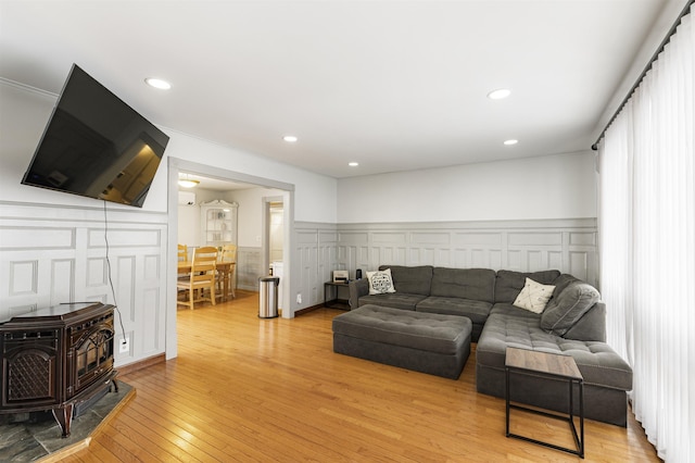 living room with light hardwood / wood-style floors and a wood stove