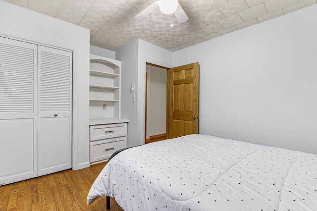 bedroom with ceiling fan, a closet, and light hardwood / wood-style flooring