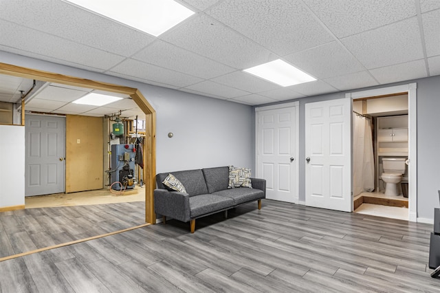 living room with light hardwood / wood-style flooring and a drop ceiling