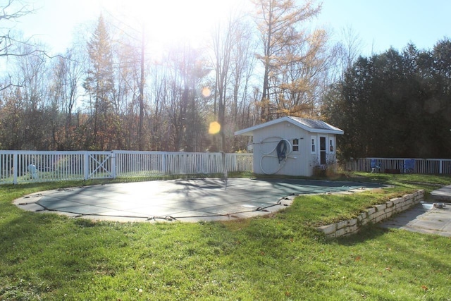 view of pool with a lawn, an outbuilding, and a patio