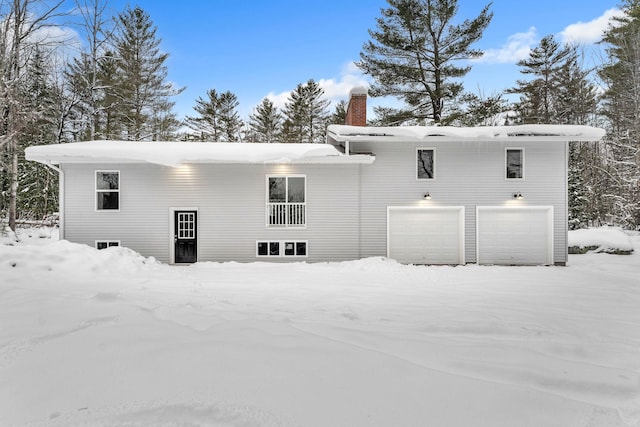 snow covered house with a garage