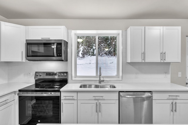 kitchen with white cabinets, backsplash, sink, and appliances with stainless steel finishes