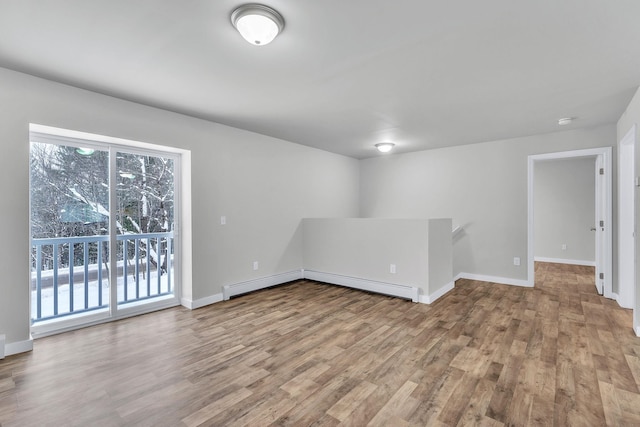 spare room with baseboard heating and light wood-type flooring