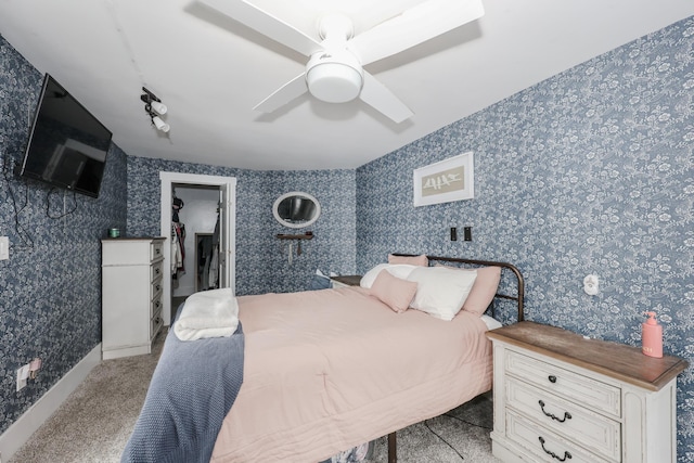 carpeted bedroom with a walk in closet, a closet, and ceiling fan