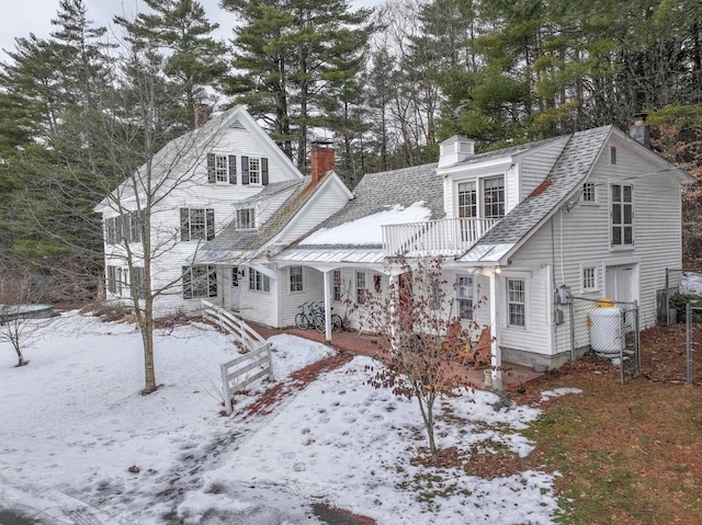 view of snow covered back of property