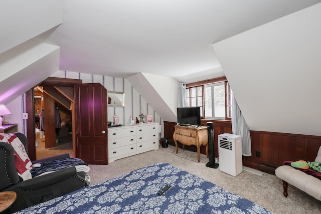 bedroom featuring light colored carpet and wood walls