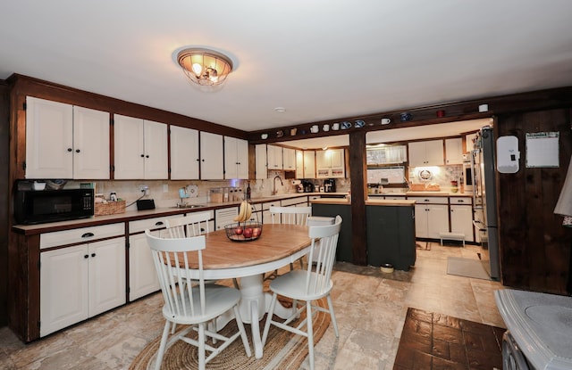 kitchen featuring backsplash, a center island, white cabinetry, and sink