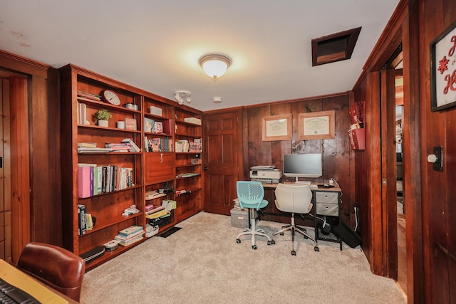 carpeted home office featuring wooden walls