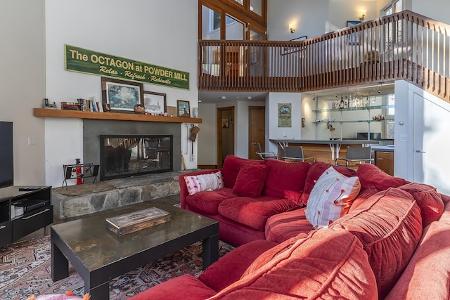 living room featuring a fireplace, bar area, and a towering ceiling